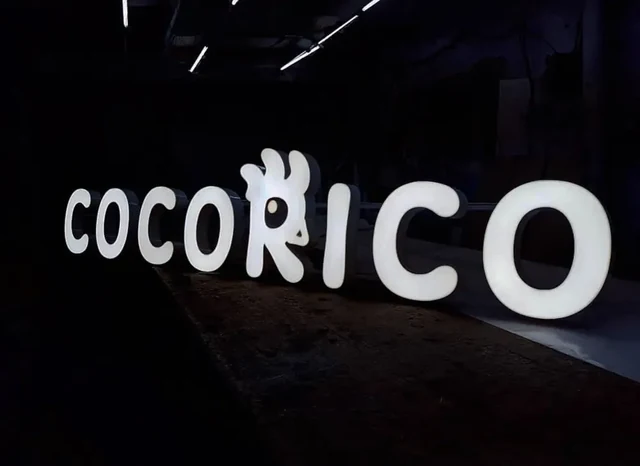 Белая объёмная вывеска Cocorico в тёмном помещении — ИЗДИДЖИТЛ